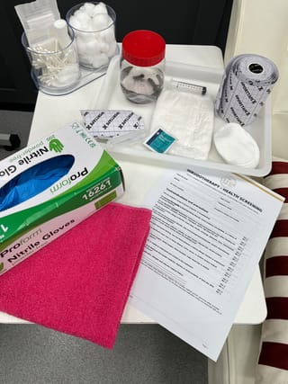 Leech therapy setup at The Leech Clinic: a lidded jar of medicinal leeches with sterile swabs, gloves and dressing materials on a tray